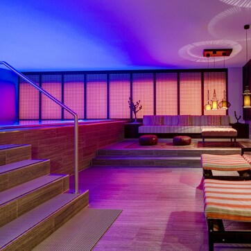 A modern interior with a staircase, seating area, and patterned walls.