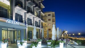 Un hotel moderno con asientos exteriores y plantas en macetas.