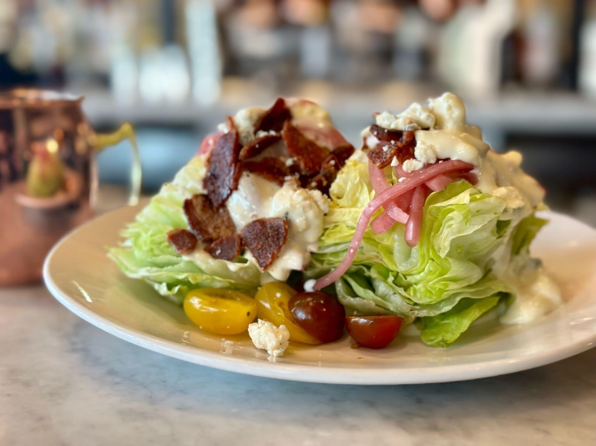 Ein Salat mit Salat, Tomaten und Speck.