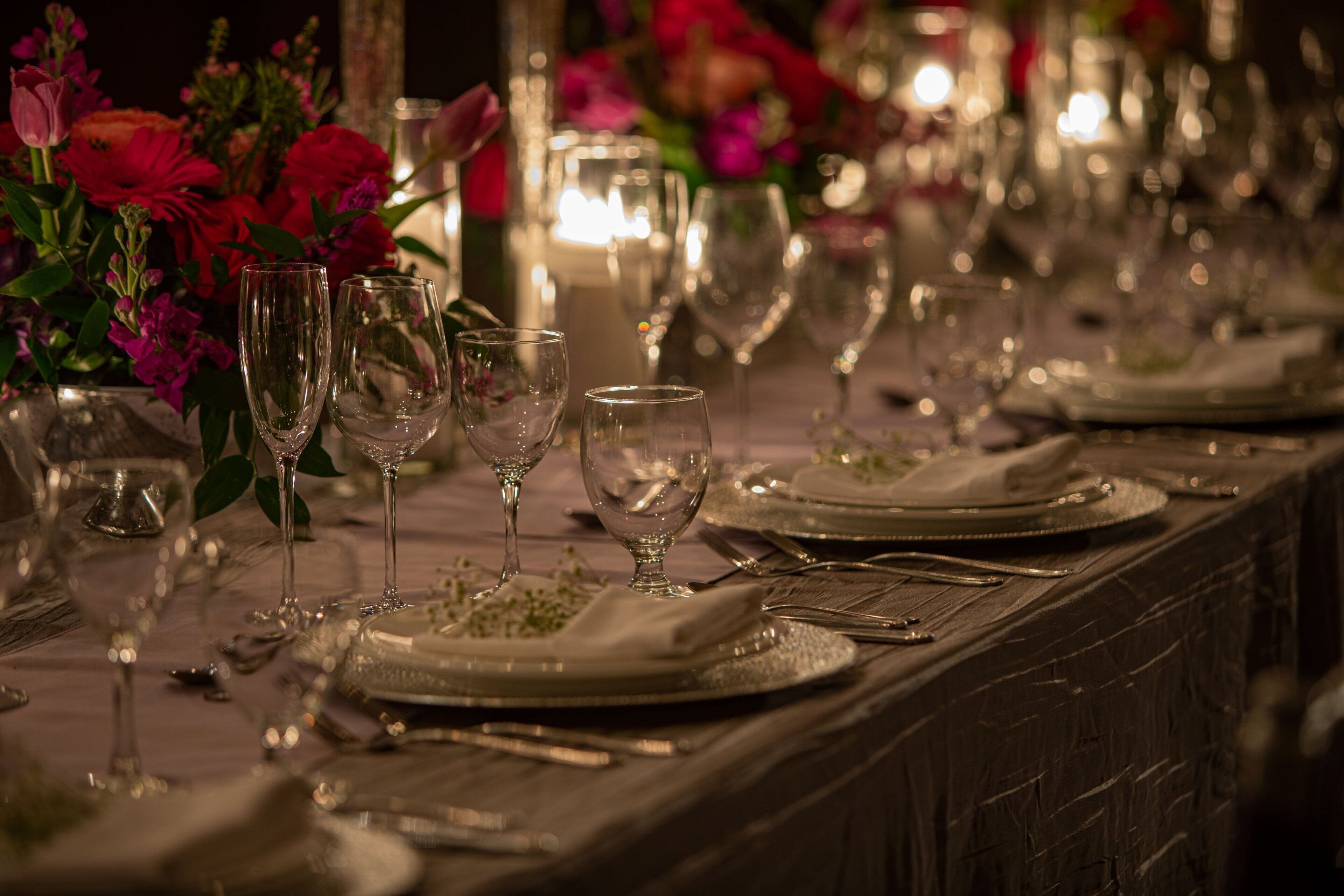 A table set for a formal event with clear glassware, plates, and cutlery.