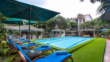 Een buitenzwembad en ligstoelen