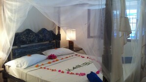 Una cama con dosel, una mesita de noche y una lámpara.