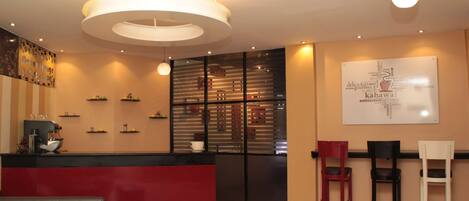 A modern cafe interior with a red counter, black and white chairs, and a word cloud poster on the wall.