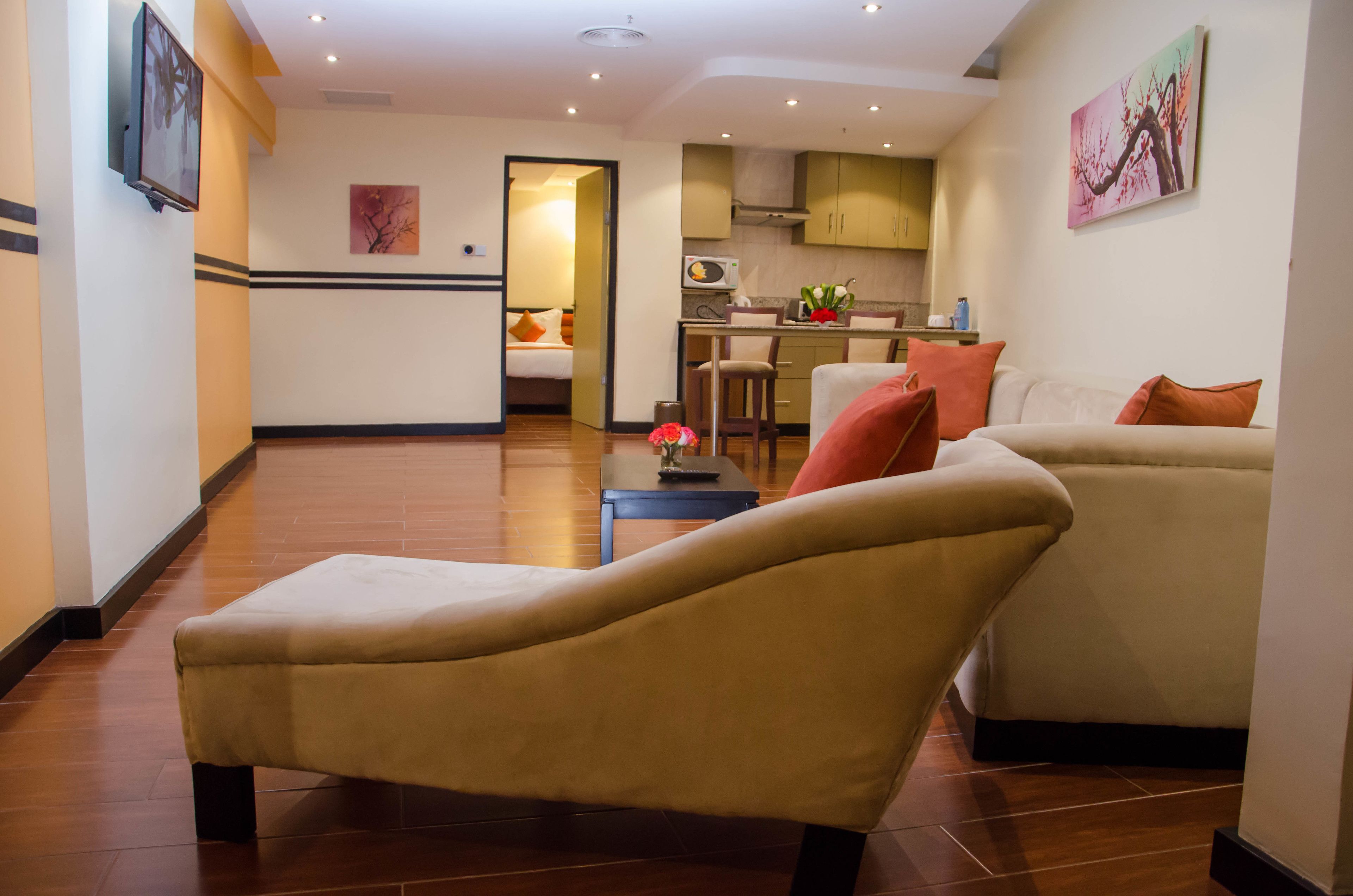 Un salon comprenant un canapé, une chaise longue et un coin repas avec une table et des chaises.