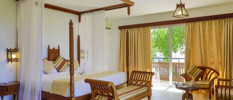 A four-poster canopy bed with a wooden headboard, a wooden bench, and a sofa with striped cushions.