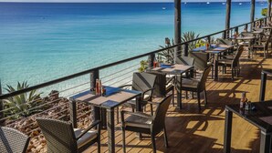 Un restaurant en bord de mer avec une terrasse offrant une vue sur l’océan.