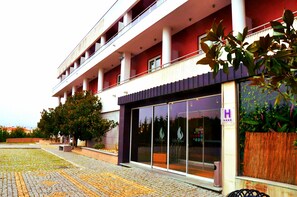 A hotel with a modern facade, large glass windows, and a sign indicating a 4-star rating. - Hotel Lusitania (Guarda)