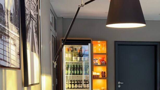 Een moderne woonkamer met een bank, een salontafel, een boekenkast en een wijnkoeler.