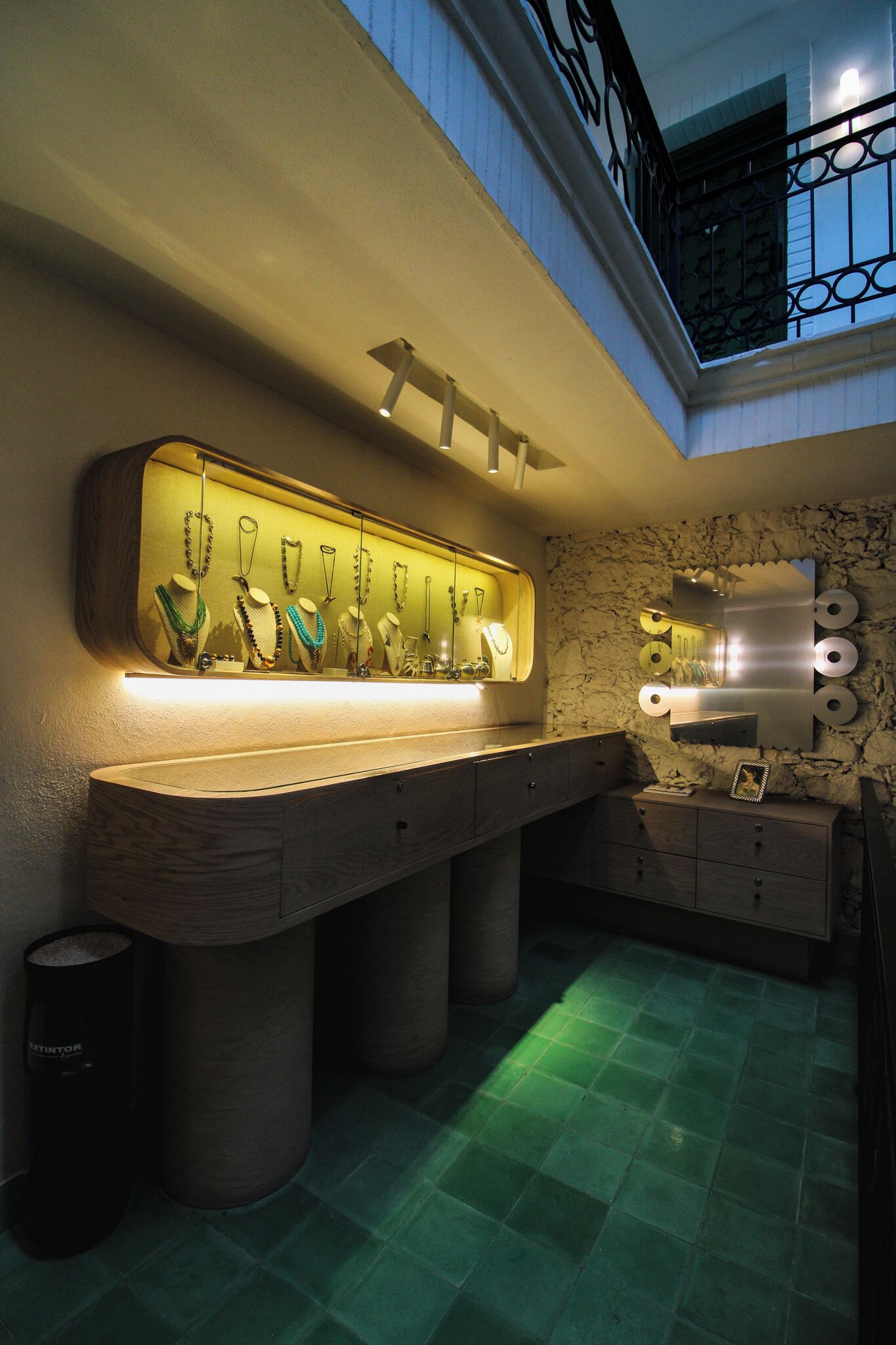 Un baño moderno con encimera de mármol, un espejo grande y suelo de azulejos verdes.