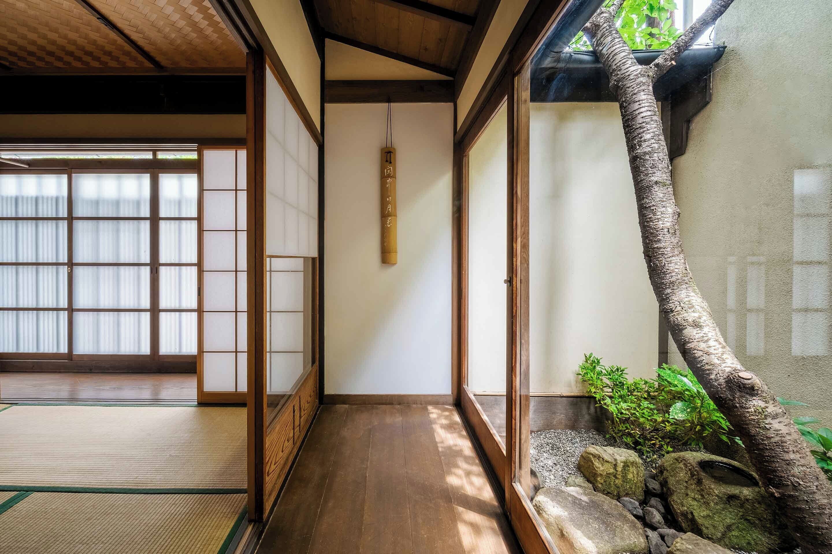 Een traditionele Japanse kamer met tatami vloeren, glijdende deuren en een kleine steentuin.