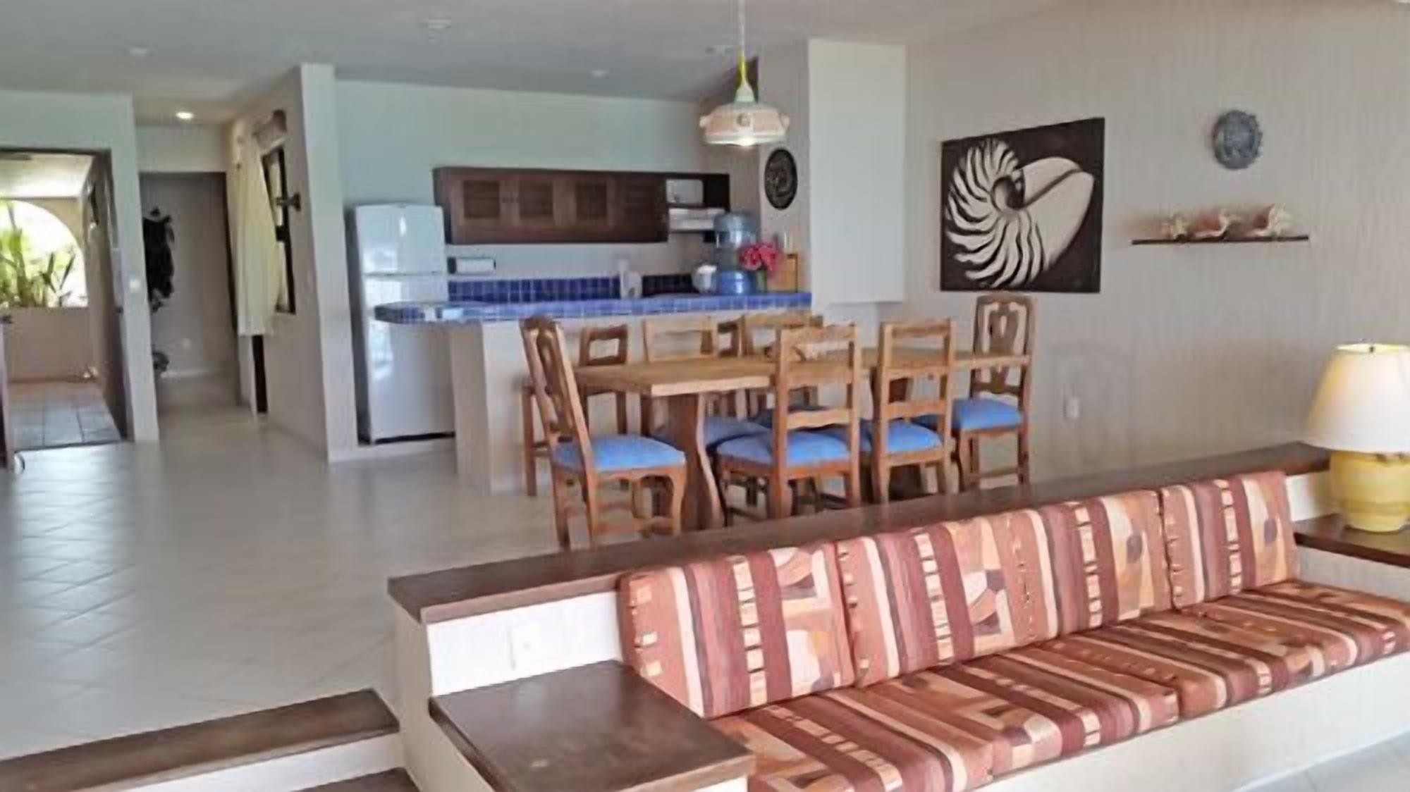 A living room with a sofa and a dining area with chairs and a table.