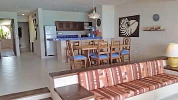 A living room with a sofa and a dining area with chairs and a table.