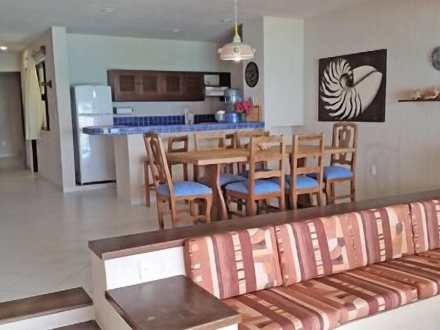 A living room with a sofa and a dining area with chairs and a table.