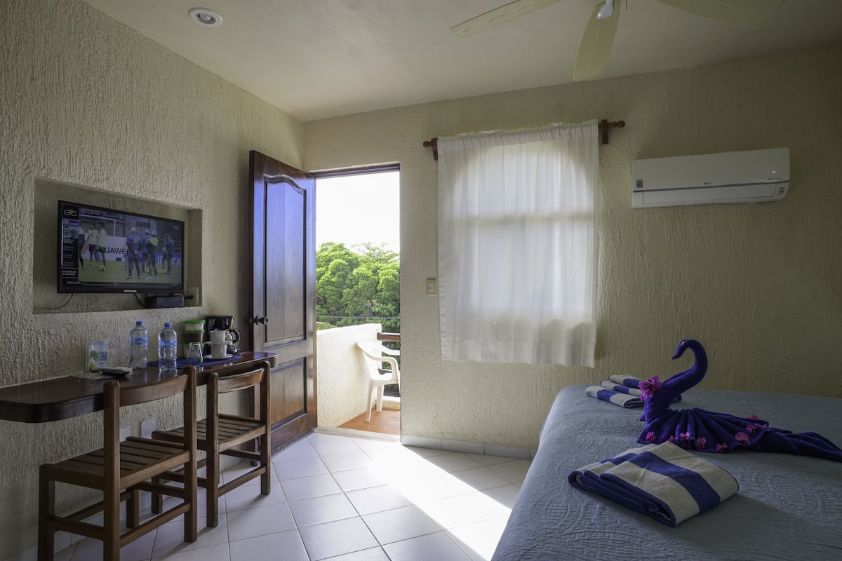 standard room, pool view | living area | flat-screen tv