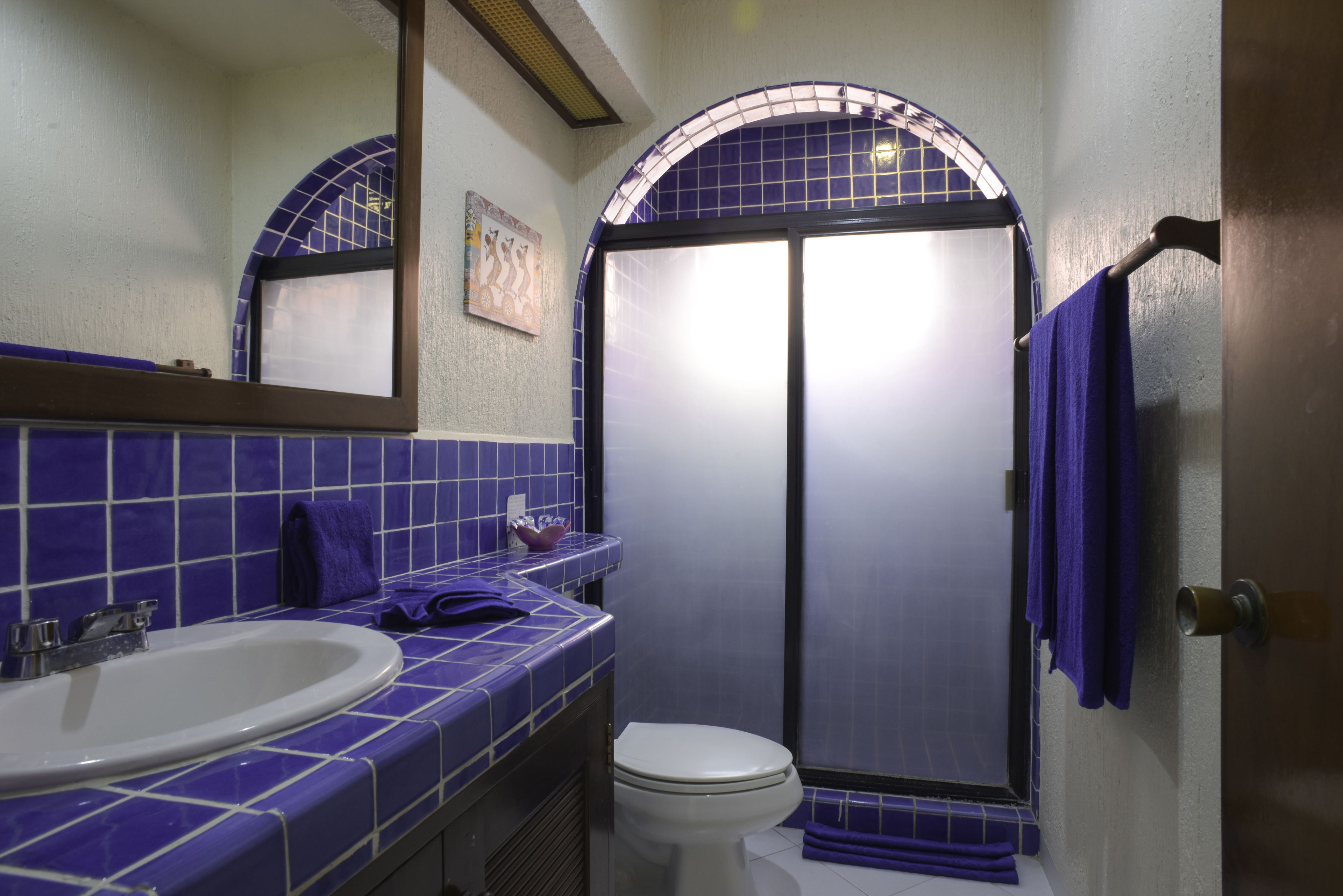 A bathroom with a sink, toilet, and shower area.