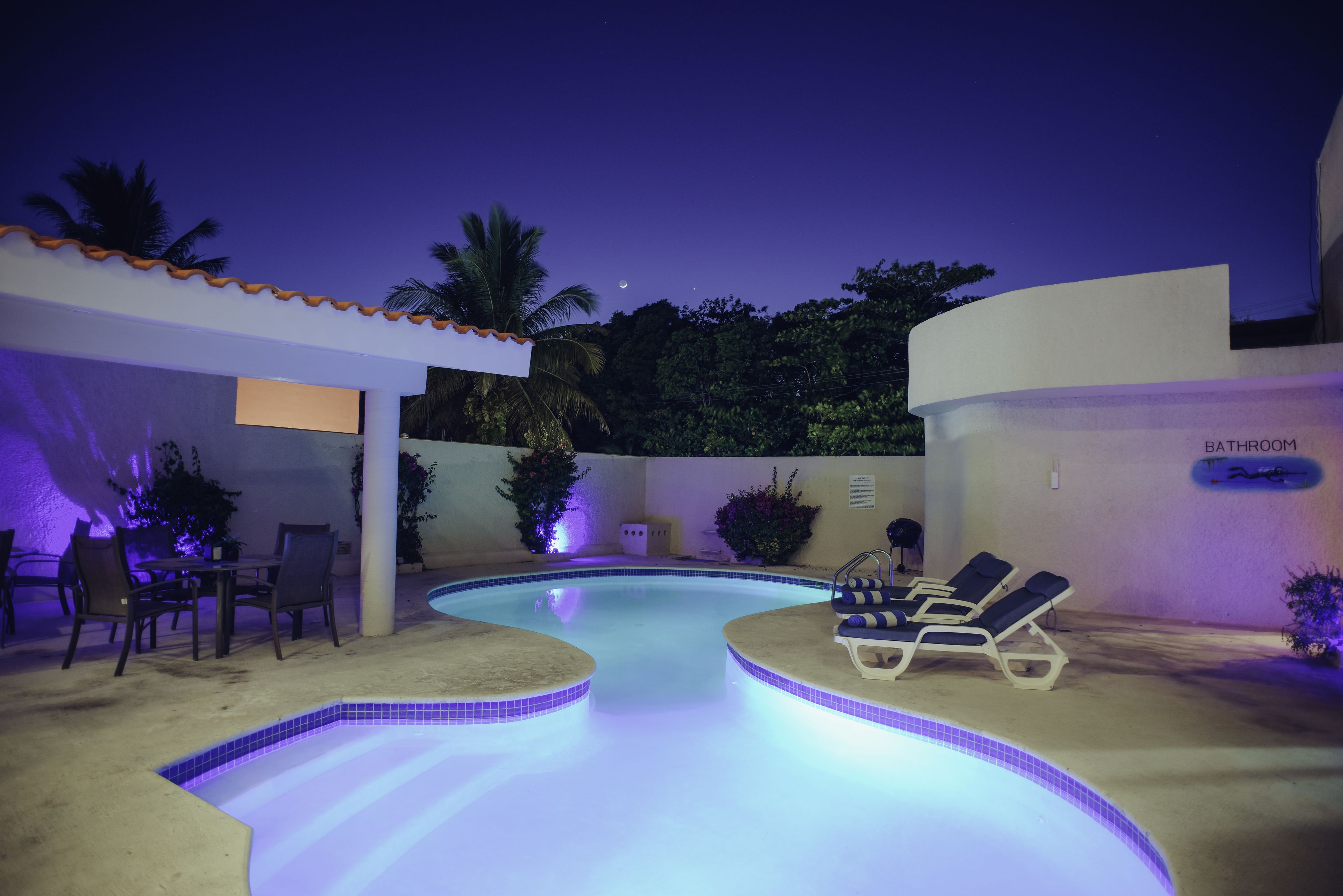 Una piscina al aire libre, sillones reclinables de piscina