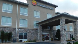 Un hôtel Comfort Inn doté d’une façade en pierre, de nombreuses fenêtres et d’une entrée abritée.