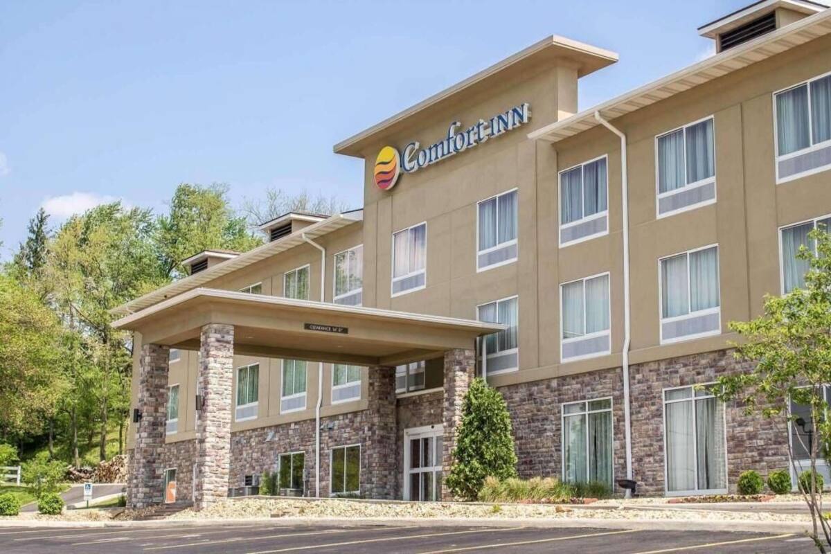 A Comfort Inn hotel with a stone facade, multiple windows, and a covered entrance.