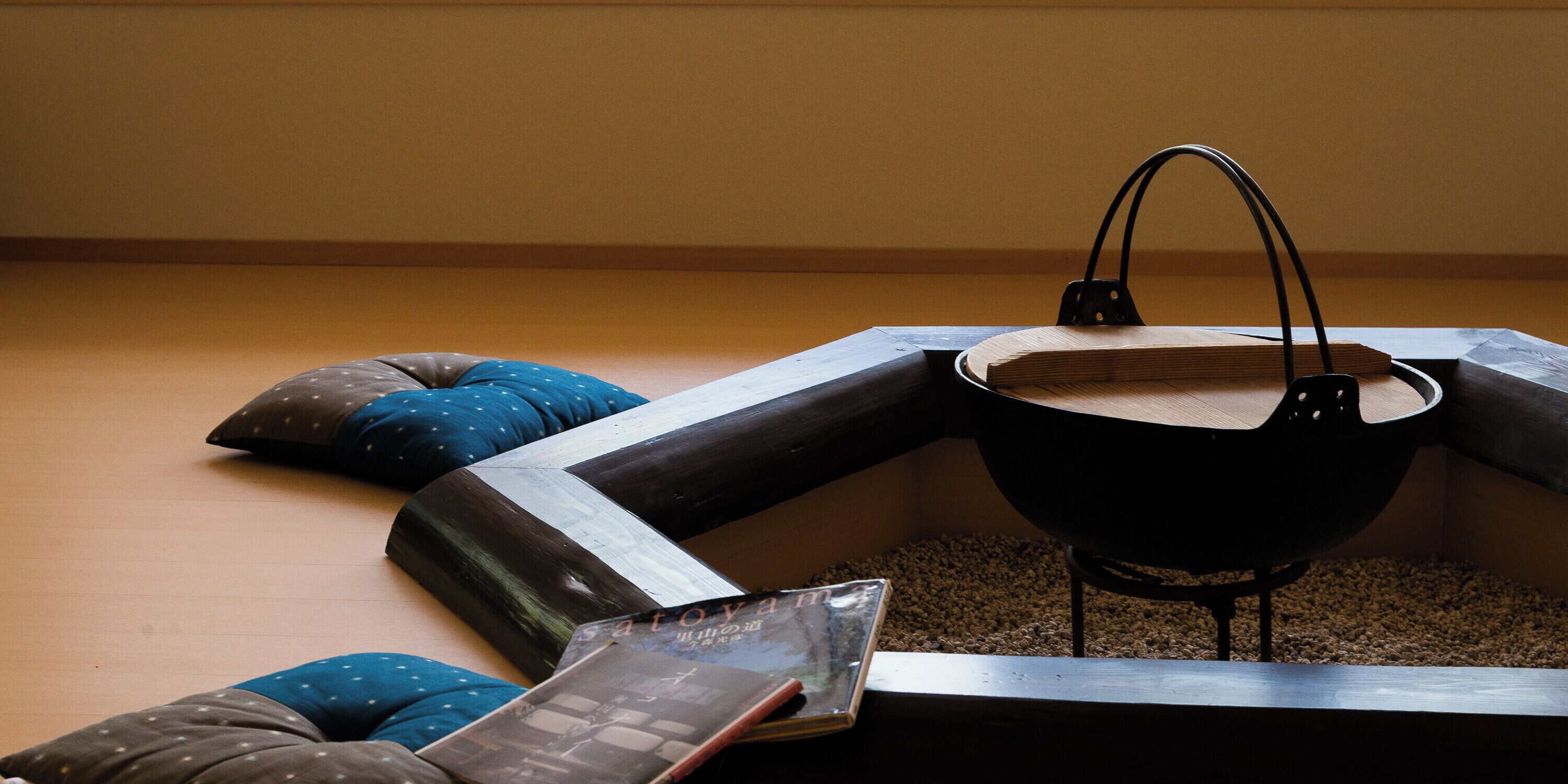 A room with a black metal table, a blue pillow, and a book on the floor.