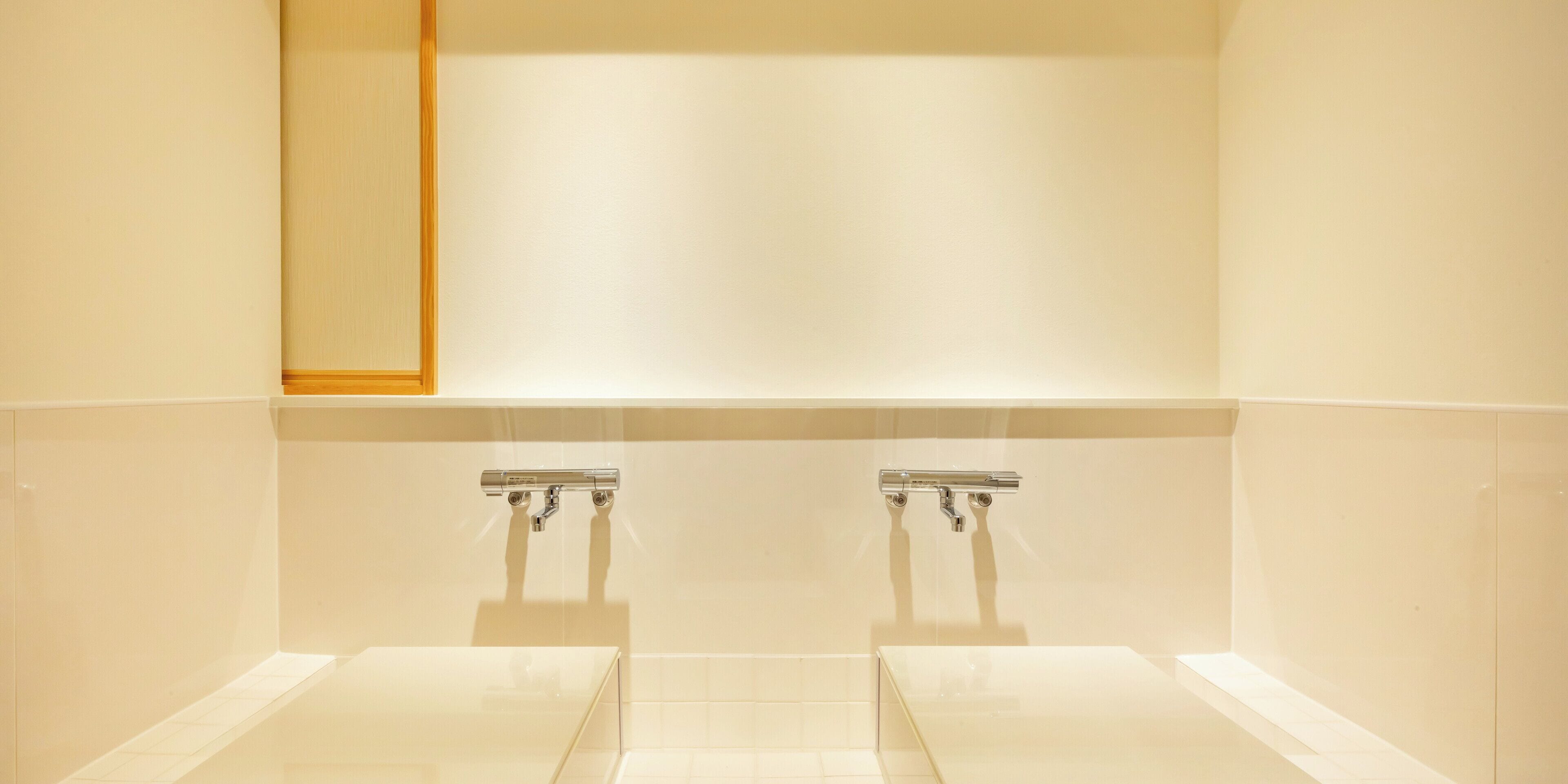 Une salle de bain avec deux lavabos, un miroir et un sol carrelé.