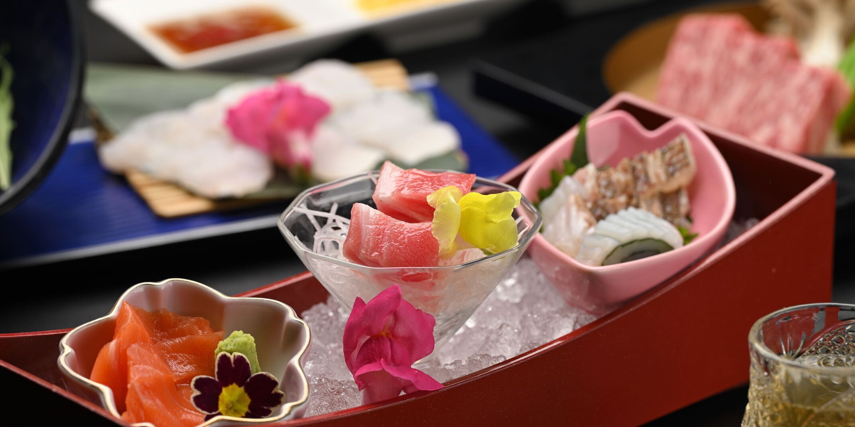 Un plateau contenant divers aliments, notamment des sashimis et des sushis, disposés sur de la glace.