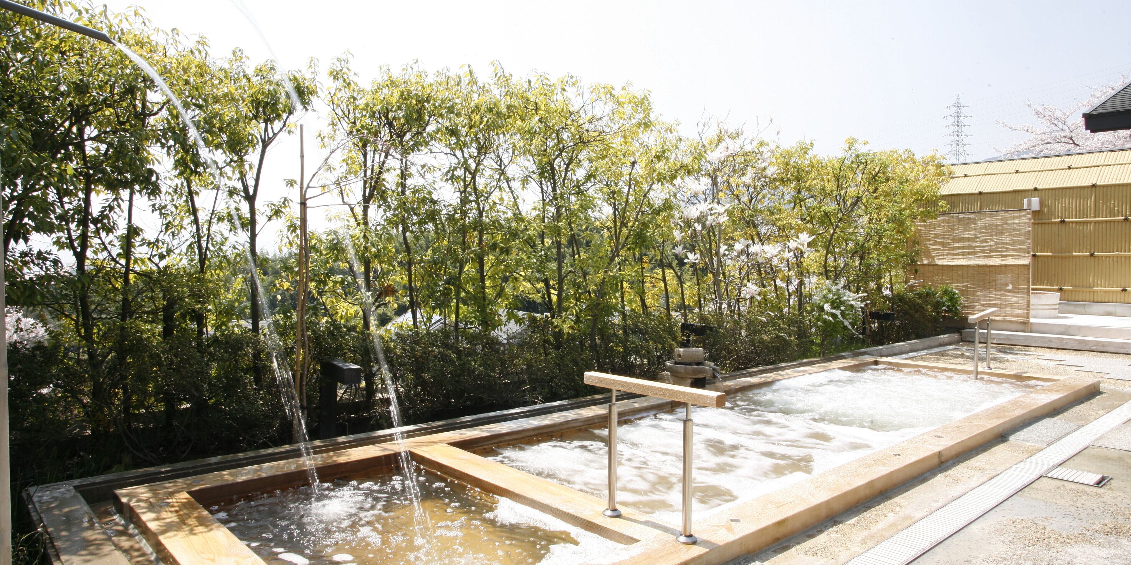 A hot spring area with wooden walkways and a stone basin.