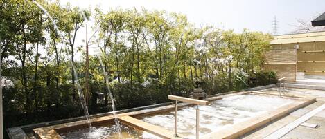 A hot spring area with wooden walkways and a stone basin.