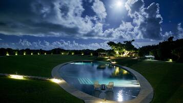 Una piscina al aire libre, sombrillas