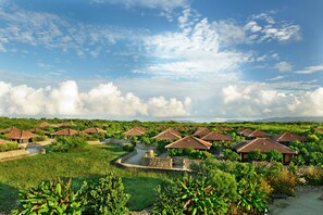 A resort with multiple bungalow-style buildings, a central water feature, and lush greenery.
