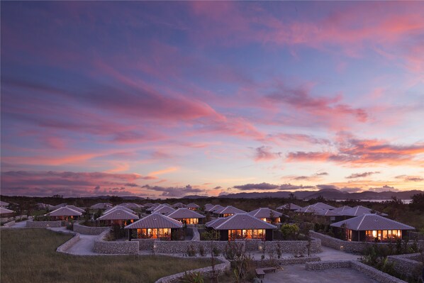 Un resort con varias villas, cada una con tejado de baldosas y rodeada de muros de piedra.