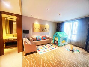 A modern living room with a sofa, a playhouse, and a patterned rug. - Holiday Inn Panjin Aqua City by IHG (Panjin)
