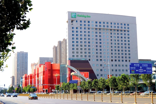 A Holiday Inn hotel with a modern design, featuring a prominent red facade and a large glass entrance.