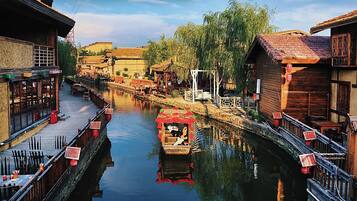 A narrow waterway flanked by traditional wooden buildings with outdoor seating areas.