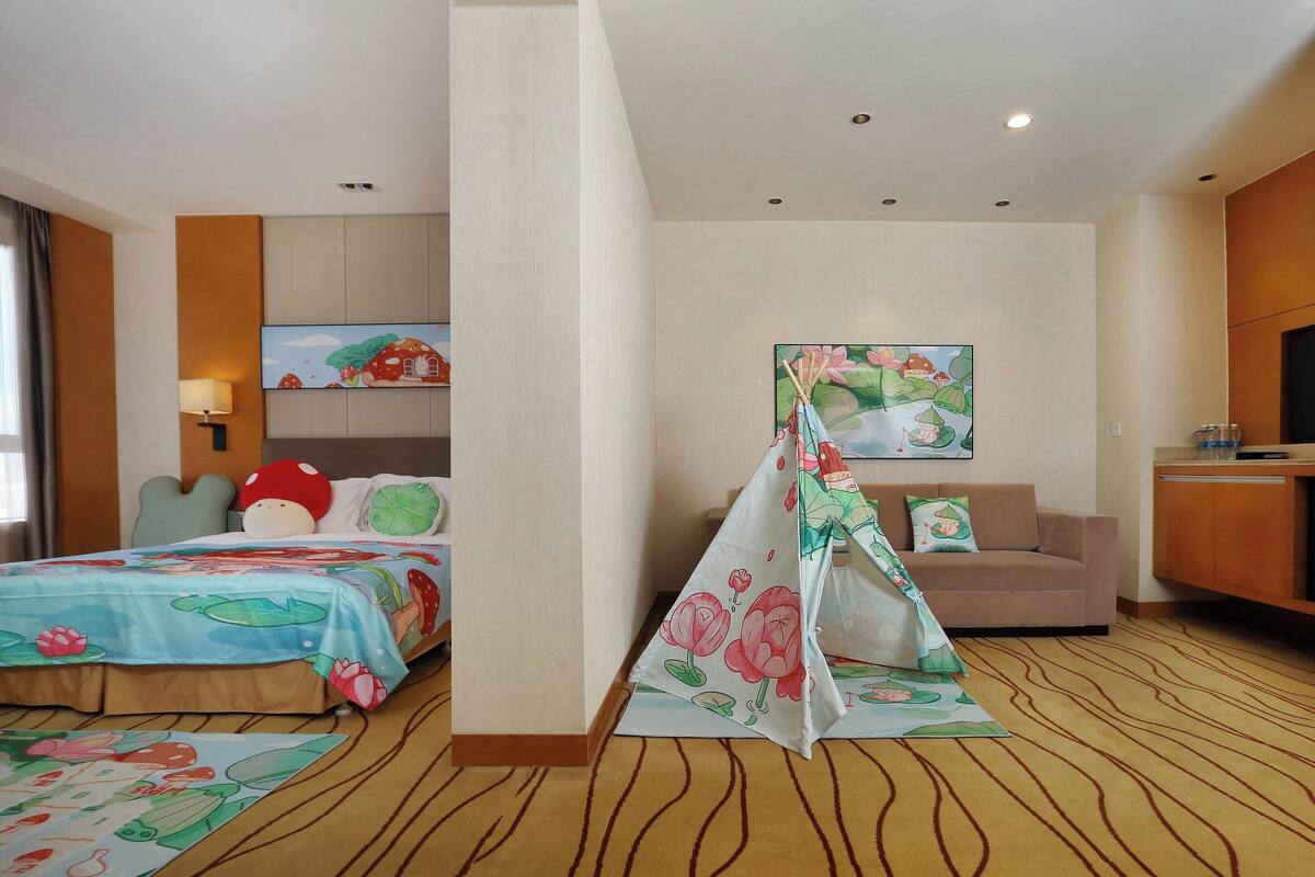 Une chambre d’hôtel comprenant un lit, un canapé, une petite kitchenette et une salle de bain.