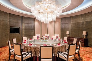 A formal dining room with a round table, chairs, and a chandelier. - Holiday Inn Panjin Aqua City by IHG (Panjin)