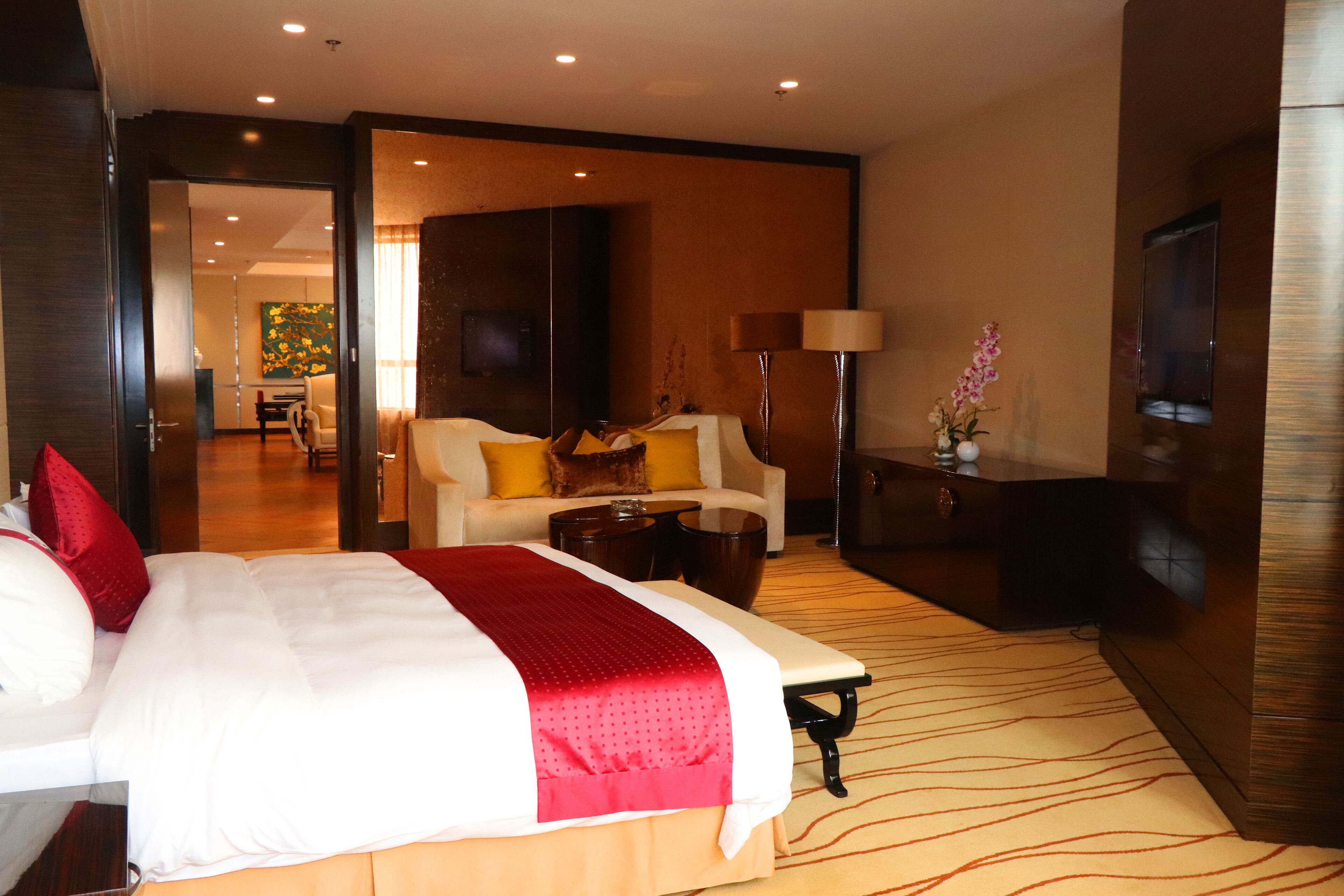 Una habitación de hotel con una cama grande, un escritorio, una silla, un televisor y una lámpara.