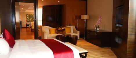 Una habitación de hotel con una cama grande, un escritorio, una silla, un televisor y una lámpara.