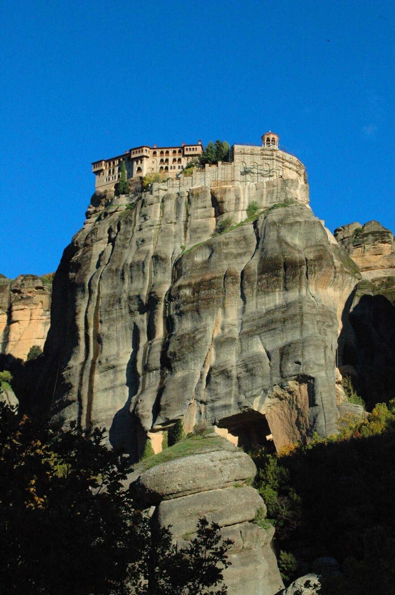 A historic building perched atop a large rock formation.
