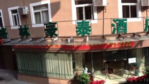 A building with a sign that reads "泰酒" and has air conditioning units installed on the exterior. - Greentree Inn Fujian Xiamen University Business Hotel (Xiamen)
