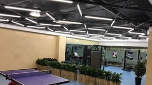 A ping pong table in a modern indoor space with a high ceiling and industrial lighting. - GreenTree Inn Hefei XiYou Road Hotel (Hefei)