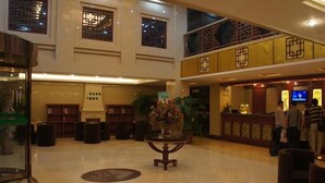 A spacious lobby with a reception desk, seating areas, and a decorative vase in the center. - GreenTree Inn Hefei XiYou Road Hotel (Hefei)