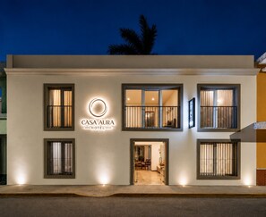 A modern hotel facade with a prominent logo, large windows, and a welcoming entrance. - Casa Aura Hotel, Mérida  (Mérida)
