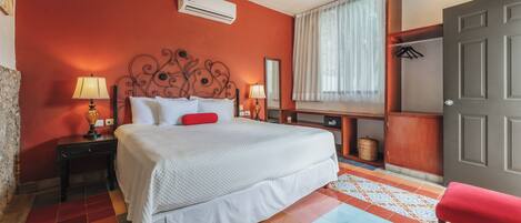 A hotel room with a bed, bedside lamps, a wardrobe, and a window with curtains.