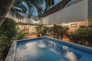 A swimming pool with surrounding greenery and a patio area. - Casa Aura Hotel, Mérida  (Mérida)