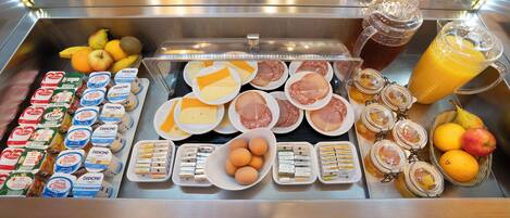 Un bufé de desayuno con diversas opciones de comida y bebidas.