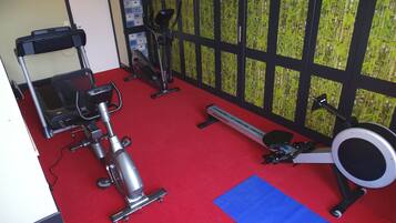 A gym with exercise equipment, a red carpet, and a bamboo-patterned wall.