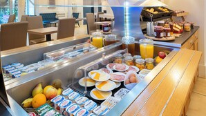 Un buffet de petit-déjeuner proposant une variété d’aliments, notamment des fruits, des fromages et des tartinades.