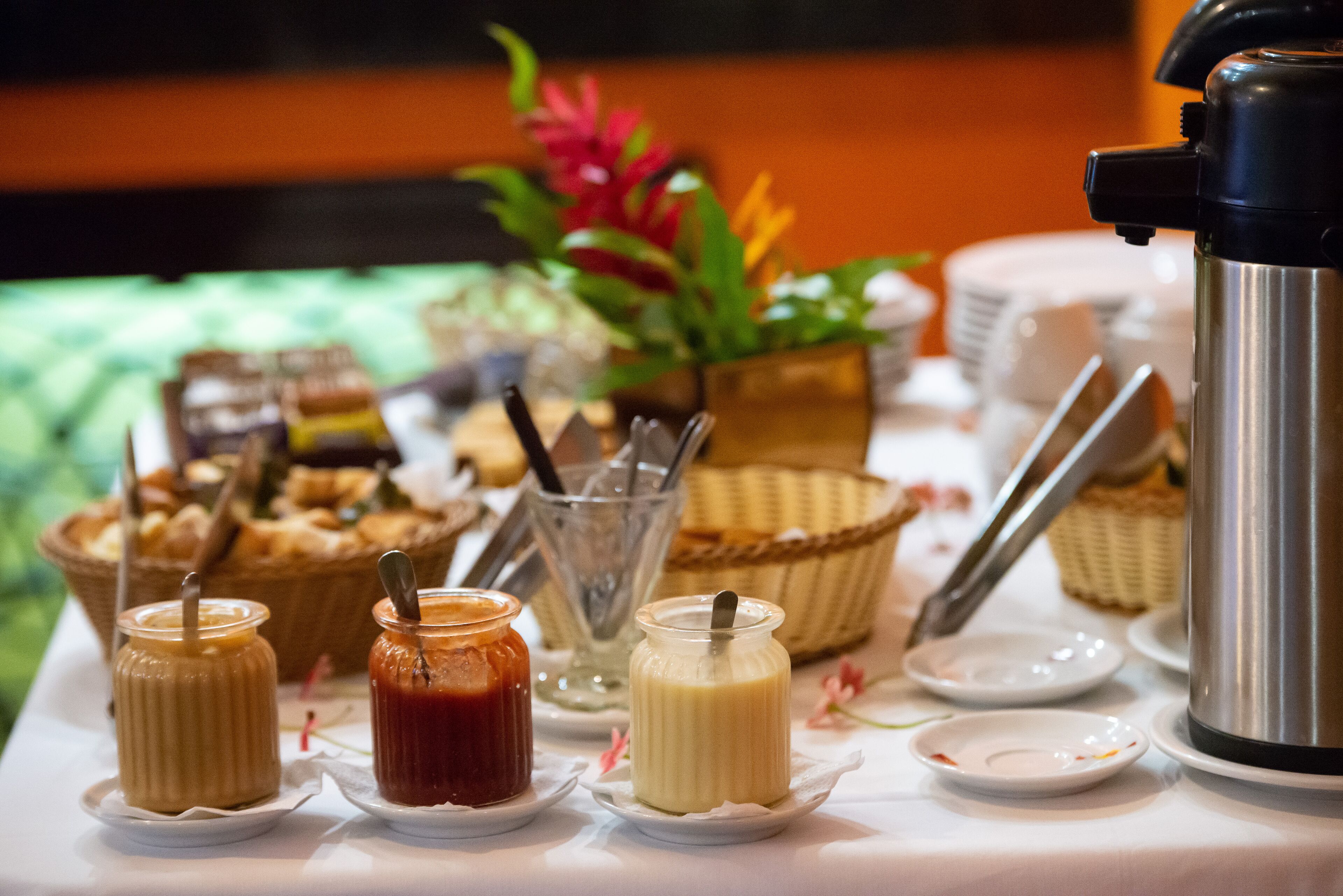 Ein Buffet mit verschiedenen Speisen, darunter Saucen und eine Kaffeemaschine.