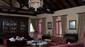A traditional library with bookshelves, a chandelier, and classic furniture. - Quinta da Gafaria (Almeirim)