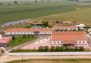 A large white building with a red-tiled roof, surrounded by green fields and solar panels. - Quinta da Gafaria (Almeirim)